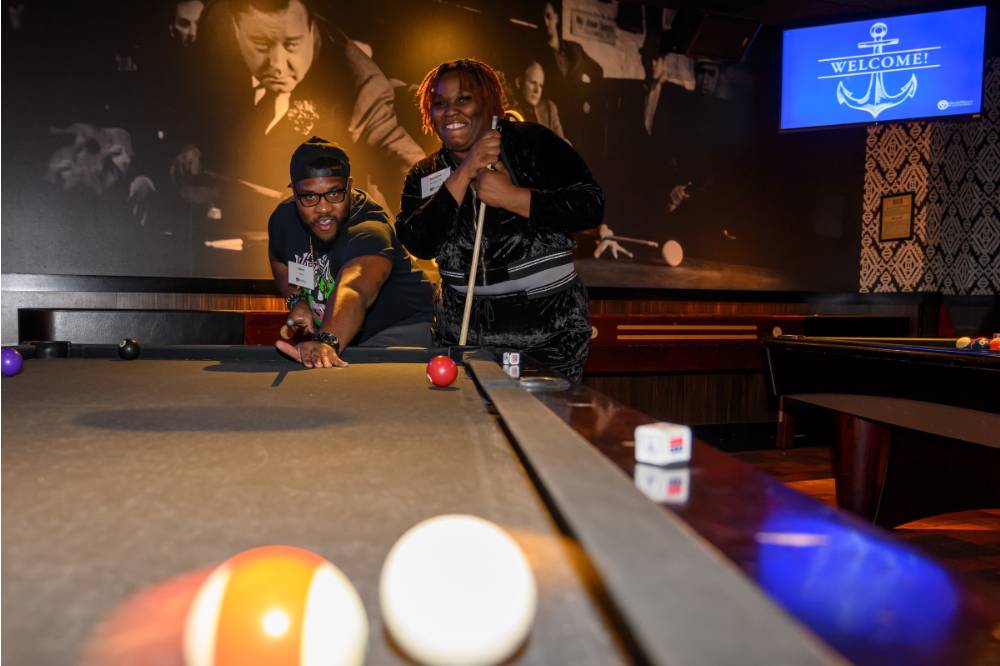 Two alumni playing pool at the event.